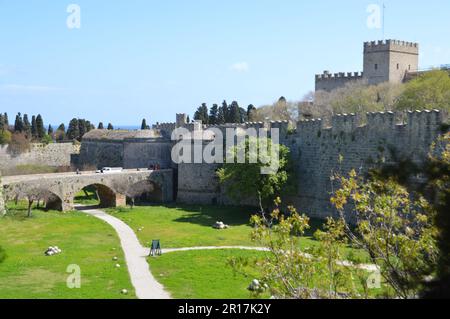 Griechenland, Insel Rhodos: Blick auf die alten Stadtmauern und den Graben mit dem Tor d'Amboise und dem Palast des Großmeisters dahinter. Stockfoto