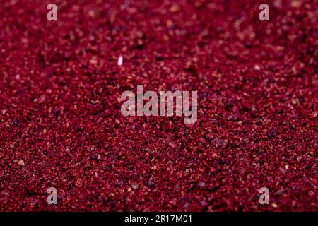 Nahaufnahme des Sumac-Hintergrunds. Getrocknete gemahlene rote Sumac-Gewürze. Gewürzkonzept. Gewürzhintergrund. Stockfoto