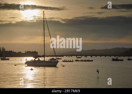 Eine Silhouette einer festgemachten Yacht an der Mündung des Teign, im Hafen von Teignmouth, Devon, Großbritannien. Stockfoto