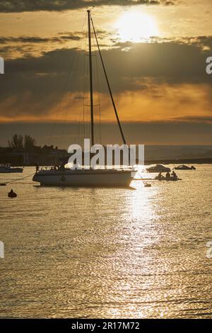 Eine Silhouette einer festgemachten Yacht an der Mündung des Teign, im Hafen von Teignmouth, Devon, Großbritannien. Stockfoto