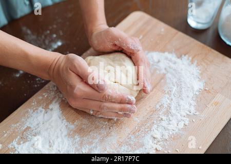 Weibliche Hände und Teig für Pizza Stockfoto