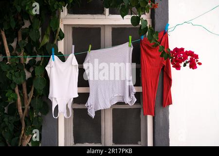 Wäsche an einem Seil in der Fensterfront. Stockfoto
