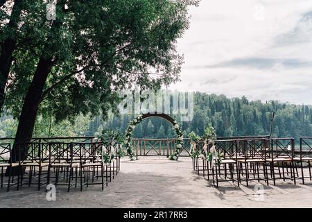 Hochzeitsbogen im Zeremoniebereich vor dem Hintergrund des Berges Stockfoto