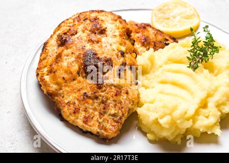 Deutsches Schnitzel mit frischem Kartoffelpüree aus nächster Nähe. Hausgemachtes paniertes Schweinefleisch. Wiener Schnitzel. Stockfoto