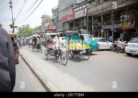 Belebte Straße in Delhi mit Tuk Tuks und Market Carts, Indien Stockfoto