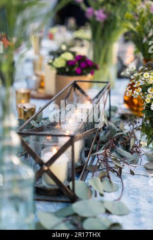 Kerzen im Halter auf dem Tisch für rustikale Hochzeitsdekorationen Stockfoto