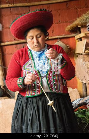 Frau in traditioneller peruanischer Kleidung, die in Chinchero, Peru, webt Stockfoto