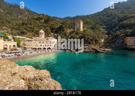 Strand mit Touristen in der Bucht von San Fruttuoso mit der alten Abtei und dem Andrea Doria Turm. Portofino und Camogli, Provinz Genua, Ligurien, Italien, Europa Stockfoto