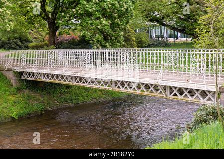 Weiße Eisenbrücke über einen Fluss in einem Park Stockfoto