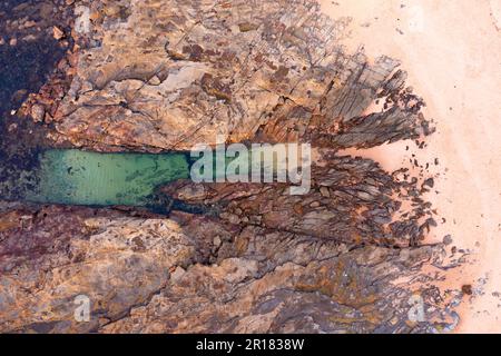 Luftaufnahme eines natürlichen Kanals in einem Felsenboden am Strand von Cape Paterson in Victoria, Australien Stockfoto