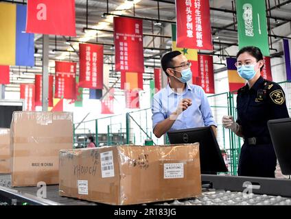 XI'an, Chinas Provinz Shaanxi. 3. Juni 2021. Yuan Zhaohui (L) spricht am 3. Juni 2021 mit einem Zollbeamten in der umfassenden Bonded Zone in Xi'an, Nordwestchina, der Provinz Shaanxi. Kredit: Liu Xiao/Xinhua/Alamy Live News Stockfoto