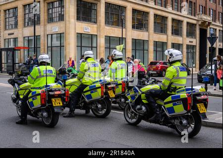 LONDON - 22. April 2023: Begleiten Sie die Polizeibeamten der Metropolitan auf ihren Motorrädern, um Ordnung und Sicherheit beim Rebellion-Schutz zu gewährleisten Stockfoto