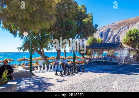 Kamari, Santorin, Griechenland - September 5. 2013: Riesenschachfiguren und das Schachbrett auf der öffentlichen Promenade markiert und Touristen Sightseeing und Relaxen Stockfoto