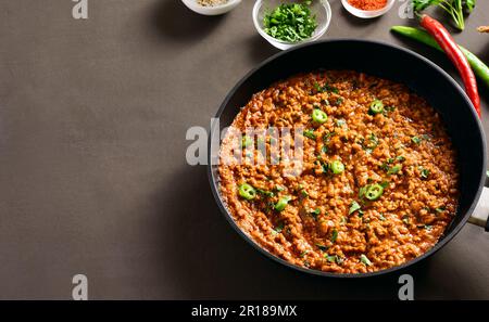 Keema Curry in der Pfanne auf dunklem Hintergrund mit Kopierbereich. Indisches und pakistanisches Gericht. Nahaufnahme Stockfoto