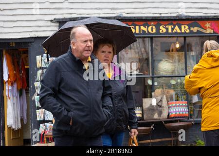 Tenterden, Kent, Großbritannien. 12. Mai 2023. Wetter im Vereinigten Königreich: Die Menschen schützen sich am meisten vor Regen mit Regenschirmen in der High Street von Tenterden, Kent, Großbritannien. Fotograf: Paul Lawrenson, Fotograf: PAL News/Alamy Live News Stockfoto