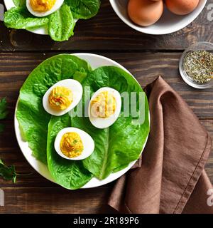 Auf dem Holzboden auf dem Teller devilierte Eier mit Paprika, Senf und Mayonnaise. Draufsicht, flach liegend, Nahaufnahme Stockfoto