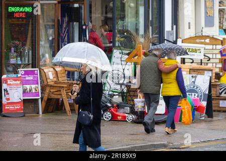 Tenterden, Kent, Großbritannien. 12. Mai 2023. Wetter im Vereinigten Königreich: Die Menschen schützen sich am meisten vor Regen mit Regenschirmen in der High Street von Tenterden, Kent, Großbritannien. Fotograf: Paul Lawrenson, Fotograf: PAL News/Alamy Live News Stockfoto