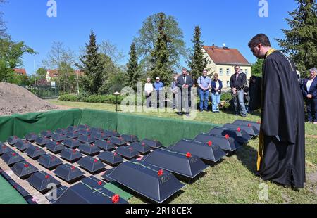 Lebus, Deutschland. 12. Mai 2023. Reverend Evgeny Murzin von der Russisch-orthodoxen Kirche in Berlin-Lankwitz veranstaltet einen Gebetsdienst für die Beerdigung von Soldaten der Roten Armee am Grab des sowjetischen Krieges. 78 Jahre nach dem Ende des Zweiten Weltkriegs hatte die Kommission der Kriegsgräber 61 Soldaten der Roten Armee in Lebus (Bezirk Märkisch-Oderland) zur Ruhe gesetzt. Sie starben in den Schlachten in Oderbruch und in der Schlacht um Berlin und wurden in den letzten Monaten von der Kommission der Kriegsgräber wieder gefunden. Kredit: Patrick Pleul/dpa/Alamy Live News Stockfoto