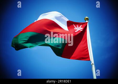 Nationalflagge des Sultanats von Oman am Fahnenmast vor dem blauen Himmel Stockfoto