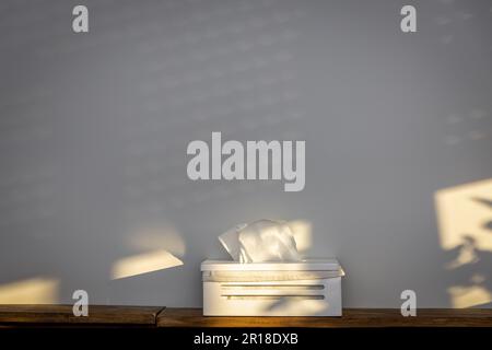 Weißes Paket von Tüchern auf einem Tisch platziert, was ihre Nützlichkeit bei der Behandlung von Allergiesymptomen, die durch die Frühlingssaison verursacht werden.oncept von Allergie reli Stockfoto