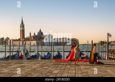 Fotoshooting am Ufer des Markusbeckens mit der Insel San Giorgio Maggiore im Morgengrauen, Venedig, Veneto; Italien Stockfoto
