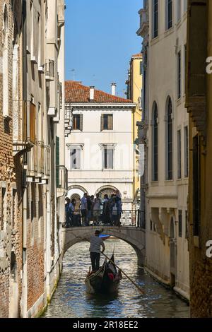 Gondel auf dem engen Kanal Rio de San Salvador mit der Bogenbrücke Ponte Manin und dem Canale Grande im Hintergrund, Venedig, Italien Stockfoto