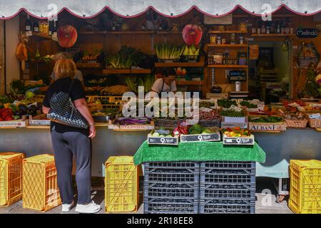 Frau, die im Sommer in Venedig, Venetien, Italien, frisches Obst und Gemüse in einem Supermarkt mit Blick auf die Straße kauft Stockfoto