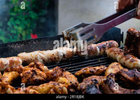 Mariniertes Fleisch, Hühnchen, Rippchen und Würstchen auf dem Grill Stockfoto