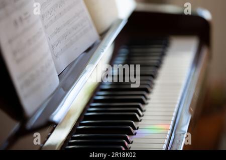Berlin, Deutschland. 30. April 2023. Auf den Tasten eines Pianos im Wohnzimmer ist eine Lichtreflexion in Regenbogenfarben zu sehen. Kredit: Viola Lopes/dpa/Alamy Live News Stockfoto