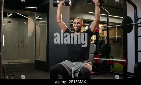 Aktiver Bodybuilder Multirassenamerikanischer Mann, der schwere Gewichte trägt Kurzhanteln Sport Training im Fitnessstudio gesunder Lebensstil männlicher Sportler Fitness Stockfoto