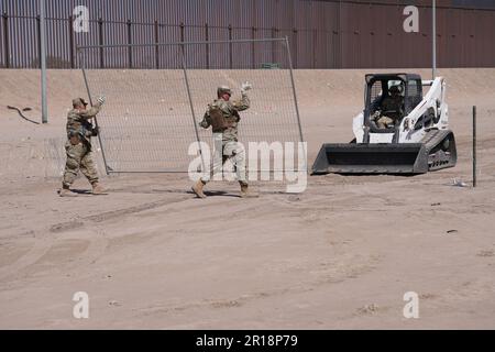 Mitglieder der Operation Lone Star Task Force West und der Texas Tactical Border Force blockieren Migranten bei der illegalen Einreise nach Texas am 11. Mai 2023 in der Nähe von El Paso am Rio Grande River. Die Einheiten nahmen Blockierungspositionen hinter einem zuvor installierten Konzertinadräht in Vorbereitung auf den Ablauf des Titels 42 ein.Mitglieder der Operation Lone Star Task Force West und der Texas Tactical Border Force blockieren Migranten am 11. Mai 2023 in der Nähe von El Paso am Rio Grande River vor der illegalen Einreise nach Texas. Die Einheiten nahmen zur Vorbereitung auf die Expir Sperrpositionen hinter einem zuvor installierten Konzertinadräht an Stockfoto