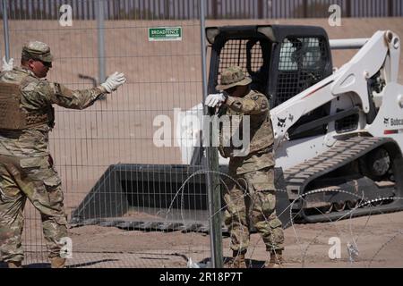 Mitglieder der Operation Lone Star Task Force West und der Texas Tactical Border Force blockieren Migranten bei der illegalen Einreise nach Texas am 11. Mai 2023 in der Nähe von El Paso am Rio Grande River. Die Einheiten nahmen Blockierungspositionen hinter einem zuvor installierten Konzertinadräht in Vorbereitung auf den Ablauf des Titels 42 ein.Mitglieder der Operation Lone Star Task Force West und der Texas Tactical Border Force blockieren Migranten am 11. Mai 2023 in der Nähe von El Paso am Rio Grande River vor der illegalen Einreise nach Texas. Die Einheiten nahmen zur Vorbereitung auf die Expir Sperrpositionen hinter einem zuvor installierten Konzertinadräht an Stockfoto