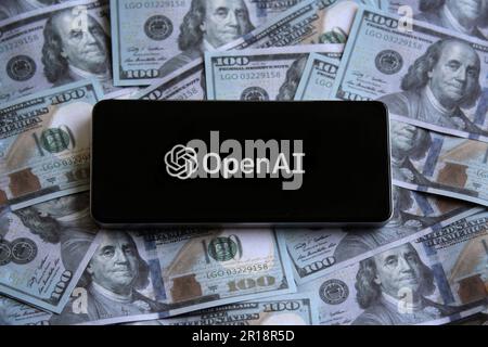 OpenAI-Logo auf dem Smartphone auf dem Geldhaufen. Stockfoto