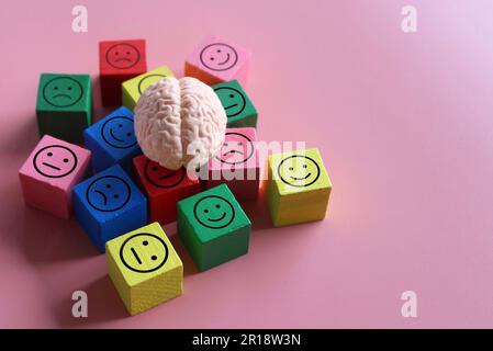 Menschliches Gehirn mit glücklicher, neutraler und trauriger Ikone. Psychische Gesundheit, Stimmungsschwankungen, bipolare Störung. Stockfoto