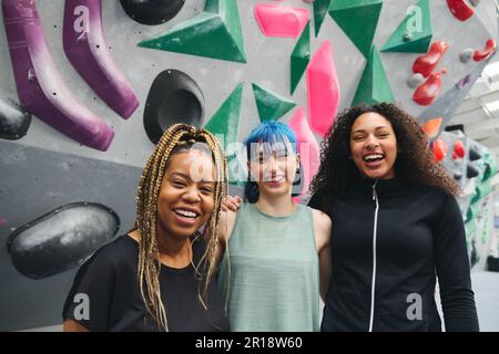 Portrait einer Gruppe von lächelnden weiblichen multikulturellen Freunden durch Kletterwand im Indoor-Aktivitätscenter Stockfoto