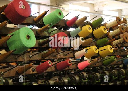 Rollen farbige Baumwolle auf einer Vintage-Textilmaschine. Stockfoto