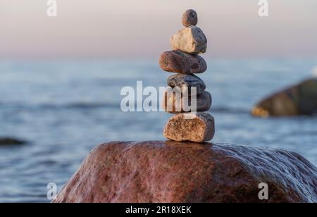 Steinpyramiden am traumhaften Ostsee-Sandstrand auf Rügen zum spektakulären Sonnenuntergang in Orange Stockfoto