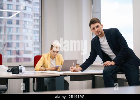 Professioneller Designer, der mit Blueprint im Büro arbeitet Stockfoto