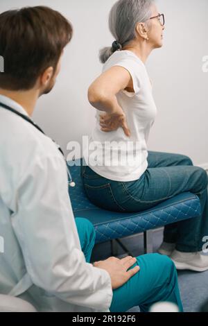 Grauhaarige Frau bei der Terminvereinbarung mit dem Traumatologen im medizinischen Zentrum Stockfoto