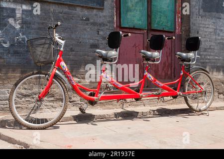 Ein chinesisches Dreirad oder Dreirad, ein Tandem für drei Personen, an einem sonnigen Tag in Pingyao, offiziell Pingyao Ancient City im Zentrum von Shanxi, China. VR CHINA. (125) Stockfoto