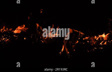 Flammen aus der Hölle. Funkenhintergrund abfeuern. Schöne, stilvolle Feuerflammen in der Nacht Stockfoto