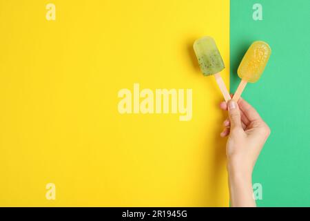 Frau mit köstlichen Eiswürfeln auf farbigem Hintergrund, Draufsicht mit Platz für Text. Obst-Eis-Eis-Eis Stockfoto