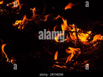 Funkenhintergrund abfeuern. Schöne, stilvolle Feuerflammen in der Nacht. Flamme mit brennenden roten, heißen Funken auf schwarzem Hintergrund Stockfoto