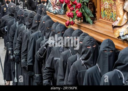 Mitglieder des Cofradía del Cristo del Gran Poder tragen während einer Semana-Santa-Prozession in Leon, Spanien, einen Paso Stockfoto