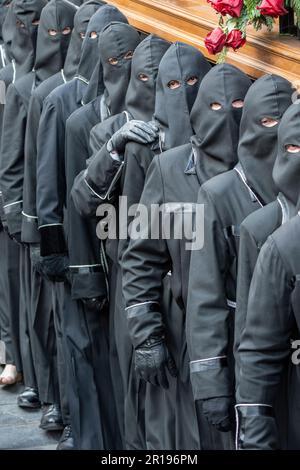 Mitglieder des Cofradía del Cristo del Gran Poder tragen während einer Semana-Santa-Prozession in Leon, Spanien, einen Paso Stockfoto