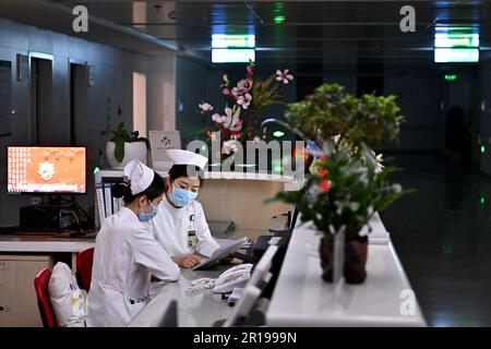 (230512) -- PEKING, 12. Mai 2023 (Xinhua) -- Krankenschwestern der Neurochirurgie Station Wang Jike (R) überreichen die Patientenzustandsdaten gegen 2 Uhr am Peking Union Medical College Hospital (PUMCH) in Peking, Hauptstadt von China, am 11. Mai 2023 an ihren Kollegen Han Jianhua. Freitag ist Internationaler Schwesterntag. Die Anzahl der Krankenschwestern in China hat in den letzten zehn Jahren ein kontinuierliches Wachstum verzeichnet, mit einem durchschnittlichen jährlichen Anstieg von 8 Prozent, laut der National Health Commission (NHC). Die Gesamtzahl der registrierten Krankenschwestern und Krankenpfleger in China lag Ende letzten Jahres über 5,2 Millionen. Stockfoto