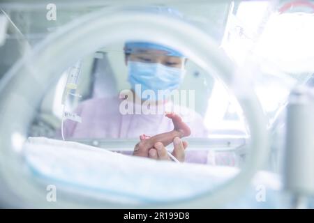 (230512) -- PEKING, 12. Mai 2023 (Xinhua) -- Yang Chujia, Krankenschwester der Neonatalen Intensivstation (NICU), überprüft die Situation eines Frühgeborenen um ca. 11 Uhr am Peking Union Medical College Hospital (PUMCH) in Peking, Hauptstadt Chinas, 9. Mai 2023. Freitag ist Internationaler Schwesterntag. Die Anzahl der Krankenschwestern in China hat in den letzten zehn Jahren ein kontinuierliches Wachstum verzeichnet, mit einem durchschnittlichen jährlichen Anstieg von 8 Prozent, laut der National Health Commission (NHC). Die Gesamtzahl der registrierten Krankenschwestern in China hatte Ende letzten Jahres 5,2 Millionen überschritten, mit groben Zahlen Stockfoto