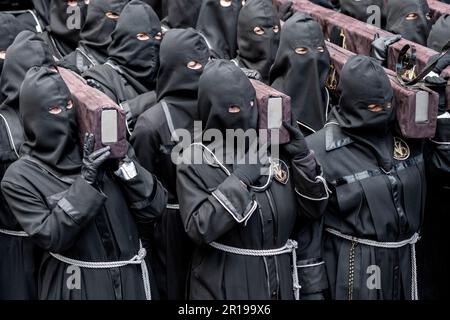 Mitglieder des Cofradía del Cristo del Gran Poder tragen während einer Semana-Santa-Prozession in Leon, Spanien, einen Paso Stockfoto