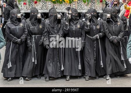 Mitglieder des Cofradía del Cristo del Gran Poder tragen während einer Semana-Santa-Prozession in Leon, Spanien, einen Paso Stockfoto
