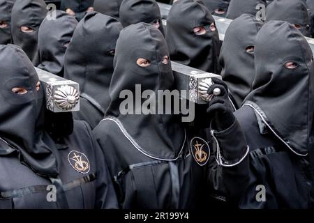 Mitglieder des Cofradía del Cristo del Gran Poder tragen während einer Semana-Santa-Prozession in Leon, Spanien, einen Paso Stockfoto